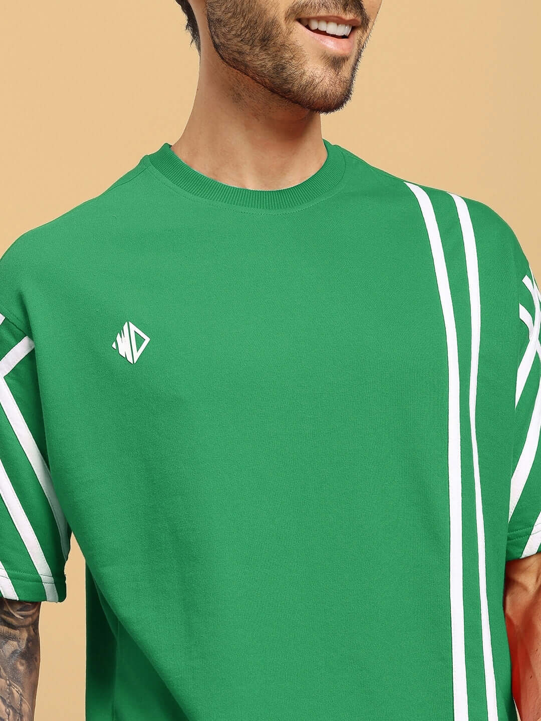 Green oversized T-shirt with white stripes, crafted from premium French Terry cotton blend, worn by model. Machine wash cold; India origin.