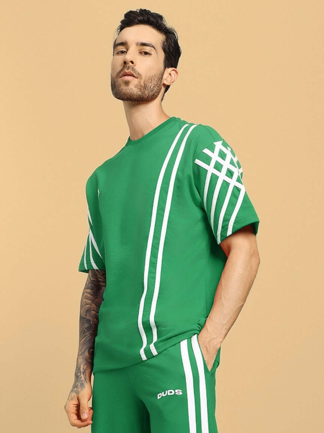 Model wearing green oversized T-shirt with white stripes, made of premium cotton French terry, by Color By Colours, 240 GSM.