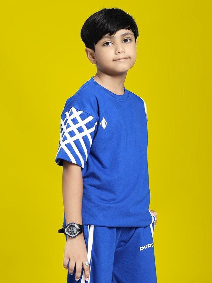 Child wearing UNITED STRIPE T-SHIRT FOR BOYS AND GIRLS BLUE with geometric sleeve design, standing against yellow background.