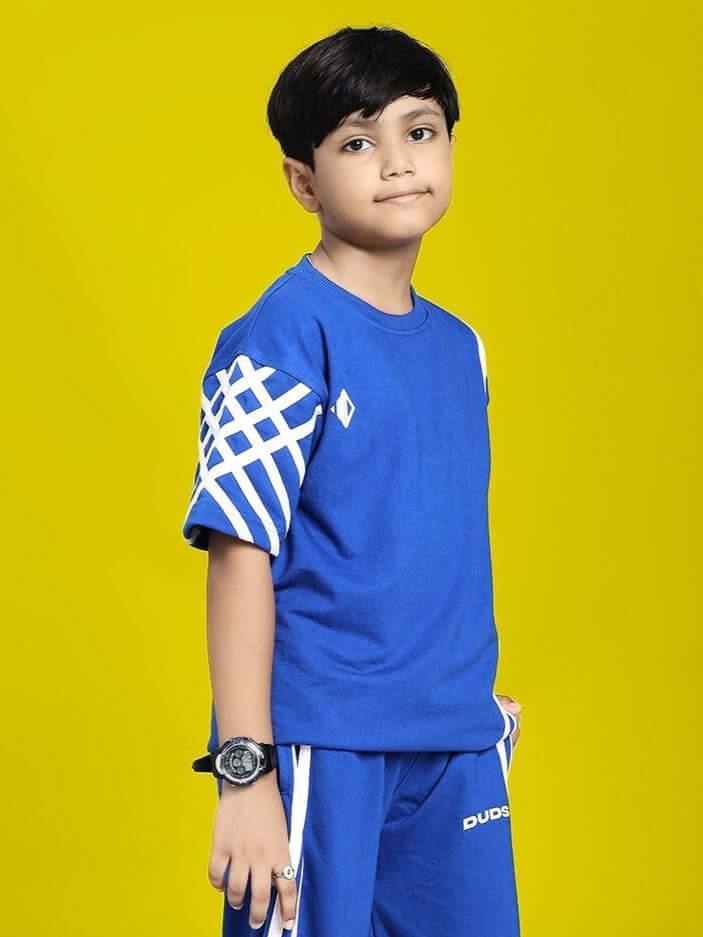 Child wearing UNITED STRIPE T-SHIRT FOR BOYS AND GIRLS BLUE with geometric sleeve design, standing against yellow background.