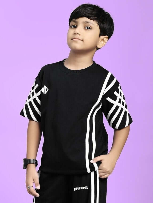 Young boy wearing UNITED STRIPE T-SHIRT FOR BOYS AND GIRLS BLACK with stylish design on purple background