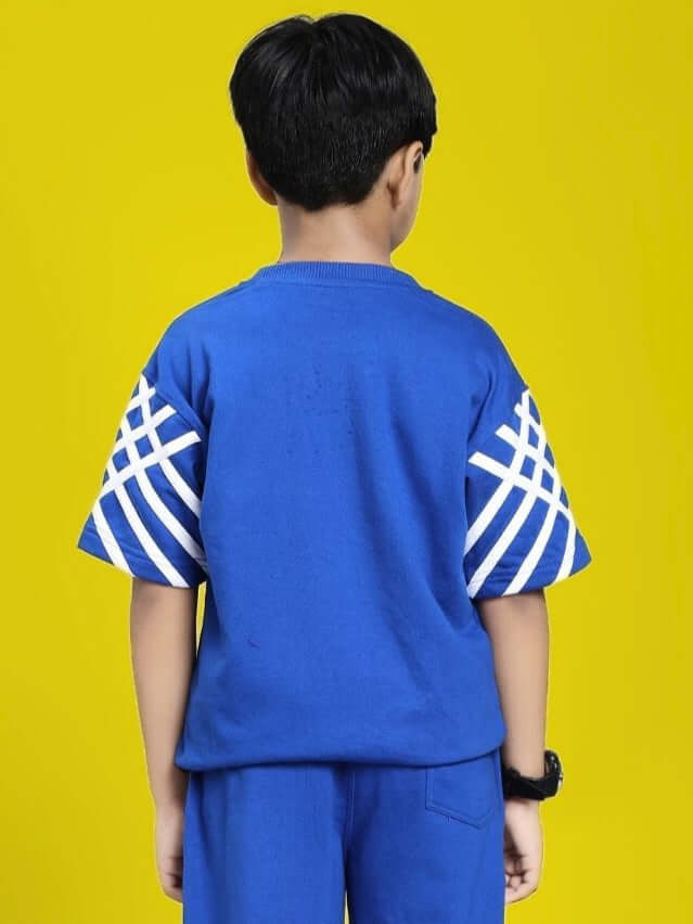 Child wearing UNITED STRIPE T-SHIRT FOR BOYS AND GIRLS BLUE with striped sleeves, back view against yellow background.