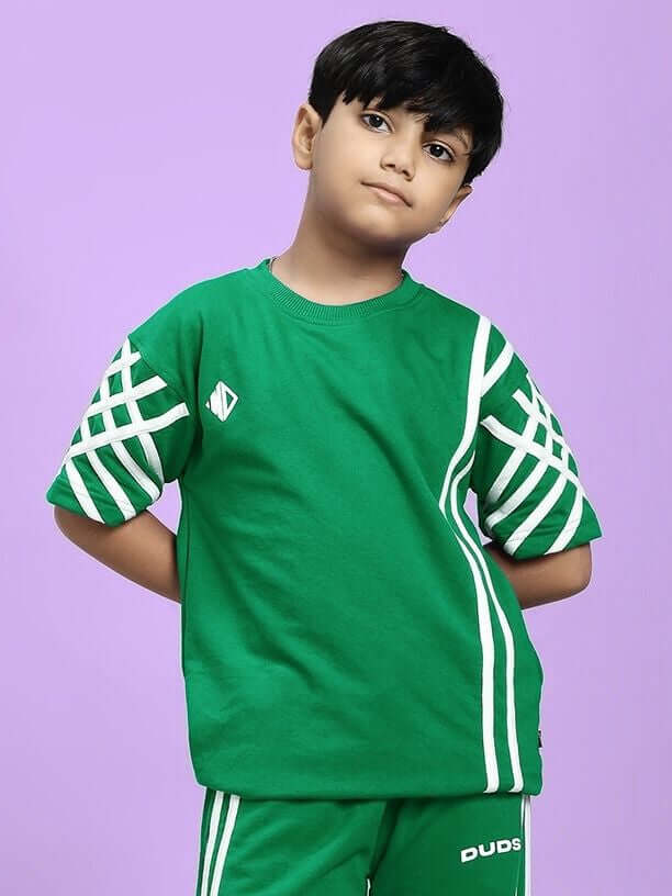Child wearing UNITED STRIPE T-SHIRT FOR BOYS AND GIRLS GREEN against purple background
