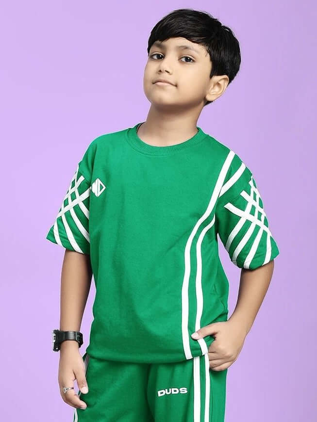 Child wearing UNITED STRIPE T-SHIRT FOR BOYS AND GIRLS GREEN against purple background.
