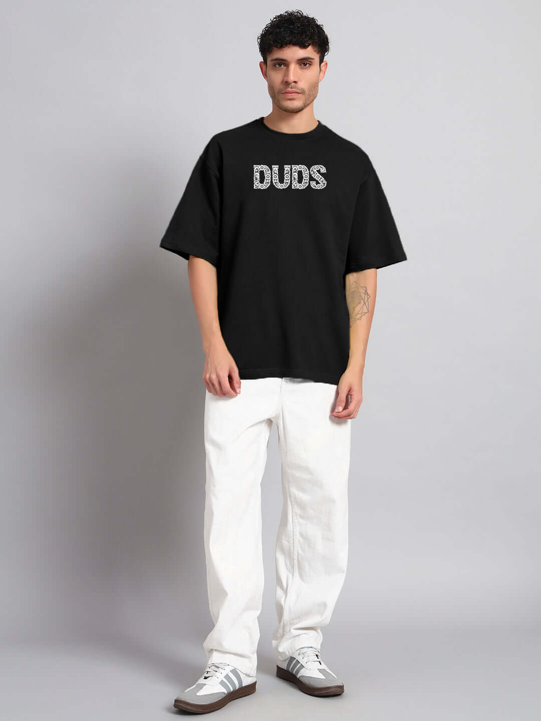 Model wearing URBAN PETAL OVERSIZED T-SHIRT BLACK with casual white pants and sneakers.