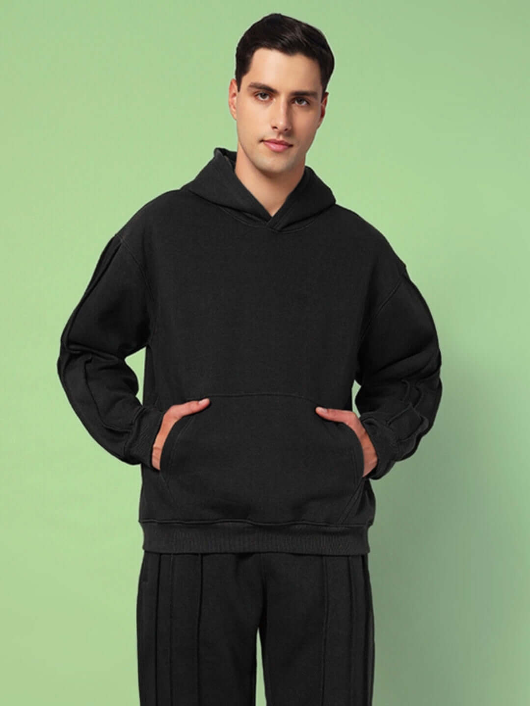 Man wearing URBAN SOLID PLATED FLEECE HOODIE BLACK with relaxed fit and modern design