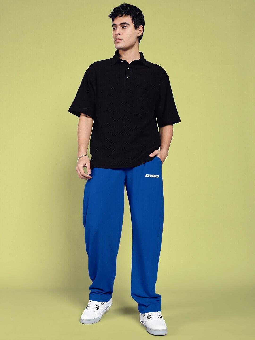 Model wearing blue Vanilla Relaxed-Fit Joggers from DUDS, paired with a black shirt, showcasing made-to-order customizable fashion.