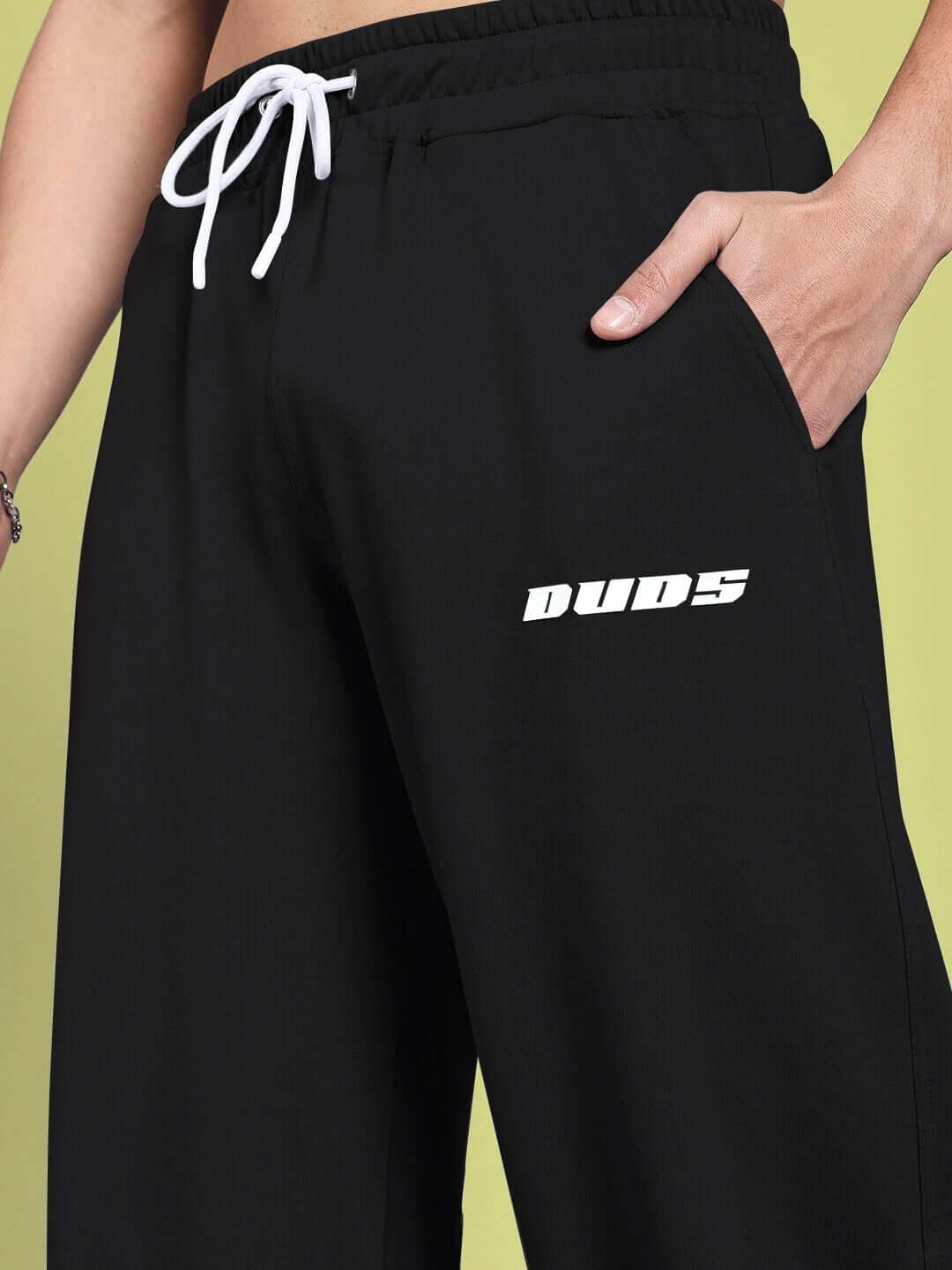 Black relaxed-fit joggers by DUDS with white drawstring, featuring logo on the side.