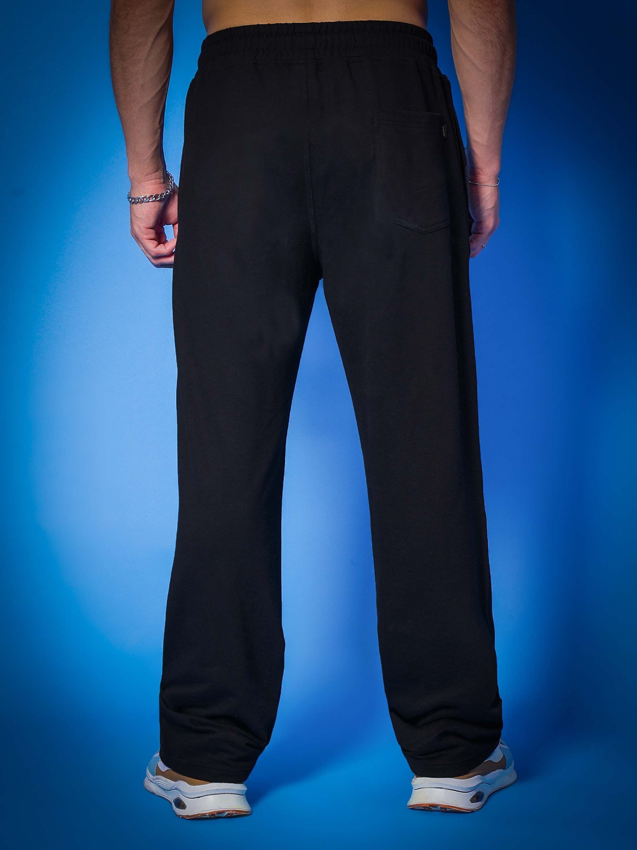 Back view of VENOM Relaxed Jogger in black, showcased on a model with blue background, highlighting comfortable fit and stylish design.