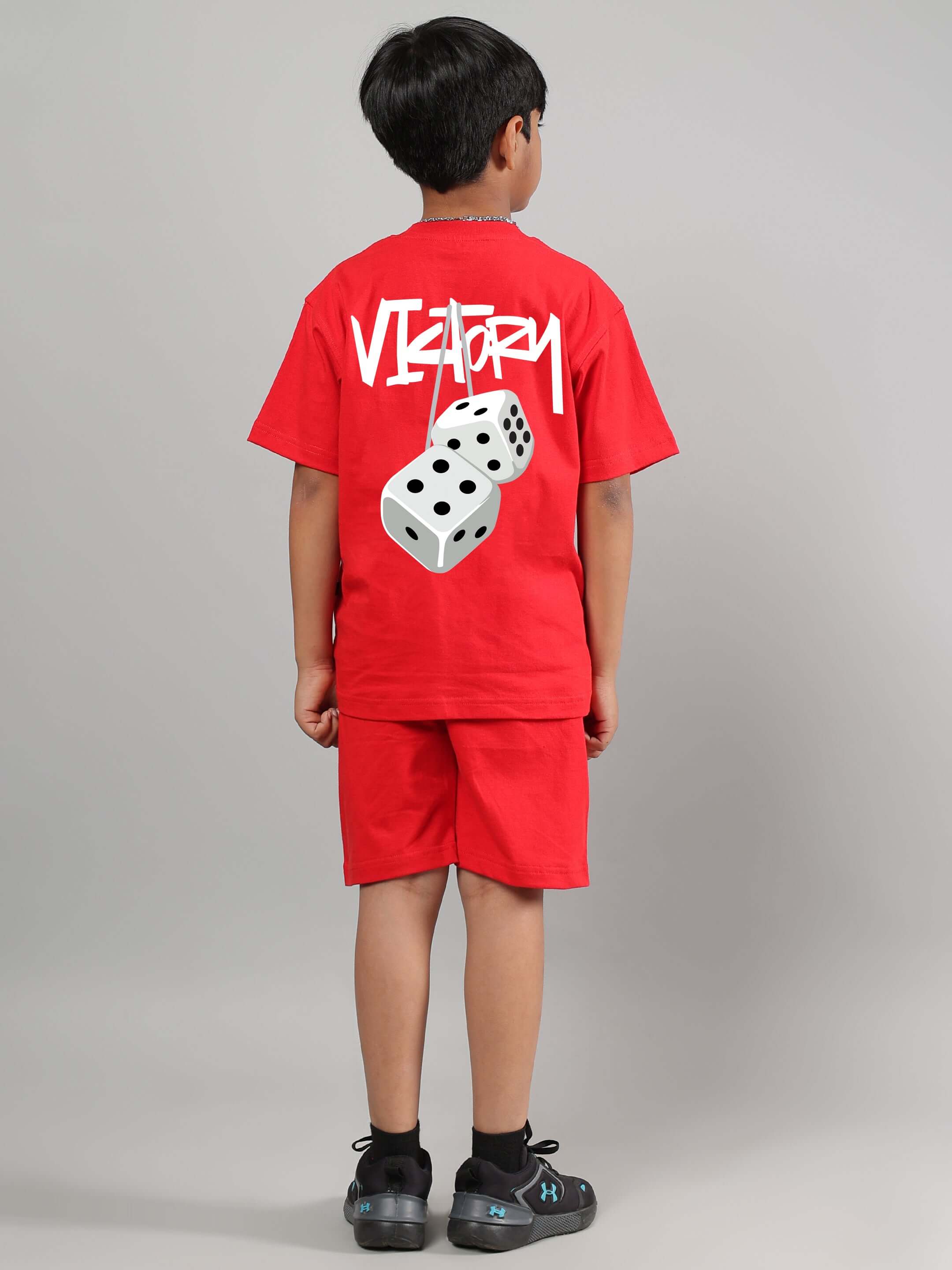 Child wearing VICTORY CO-ORD FOR BOYS GIRLS RED set with graphic t-shirt and shorts, back view