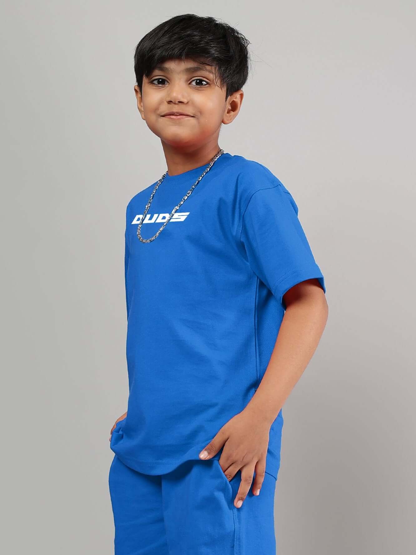 Child wearing a vibrant blue Victory T-shirt by DUDS, perfect for boys and girls, featuring a casual and comfortable fit.