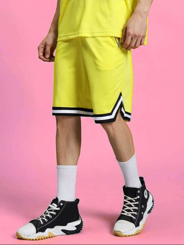 VIGOR REGULAR FIT SHORTS YELLOW on model standing in black sneakers, pink background