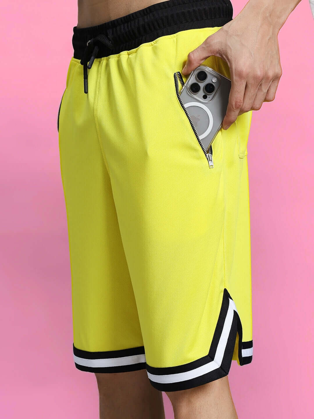 VIGOR REGULAR FIT SHORTS YELLOW with pocket and drawstring detail, showing a mobile phone being stored in pocket.