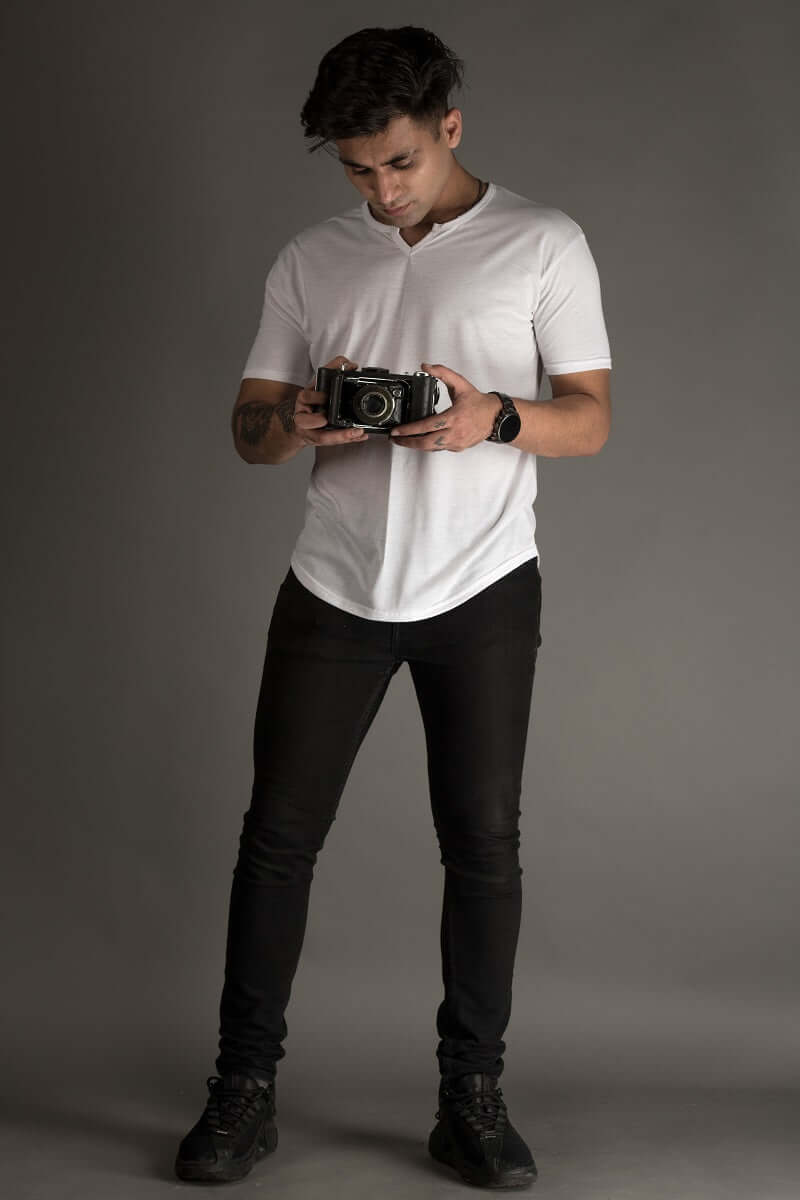 Man wearing Viking regular fit white t-shirt holding a camera, showcasing casual style with bio-washed 100% cotton fabric.