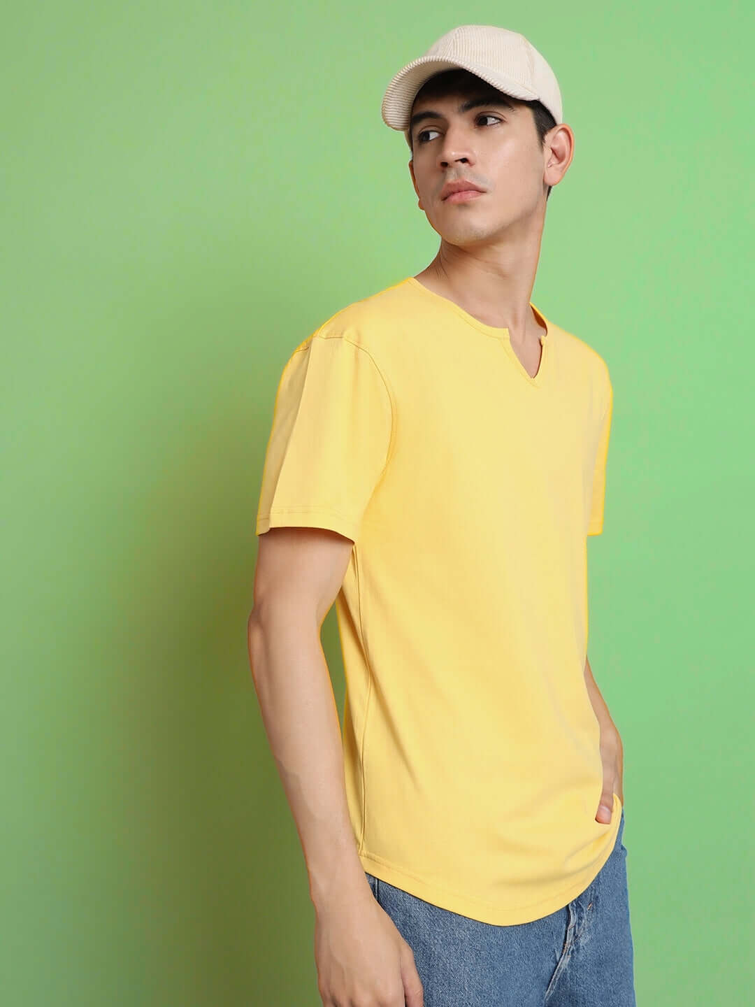 Man wearing Viking Regular Fit T-Shirt in yellow, made from 100% cotton, standing against a green background.