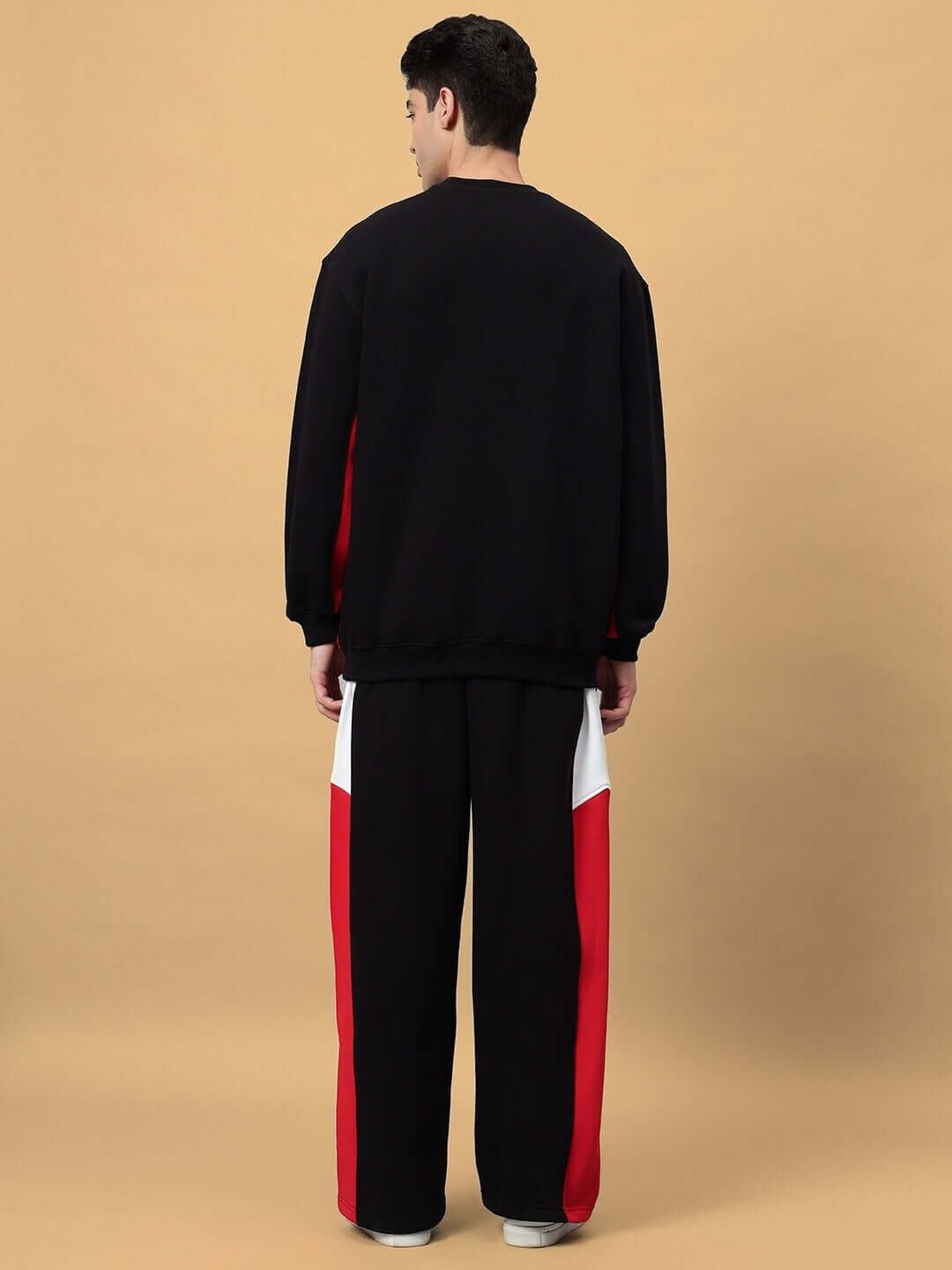Model wearing WD FERVID COLORBLOCK CO-ORD in black, showcasing the back view with striking red and white accents.