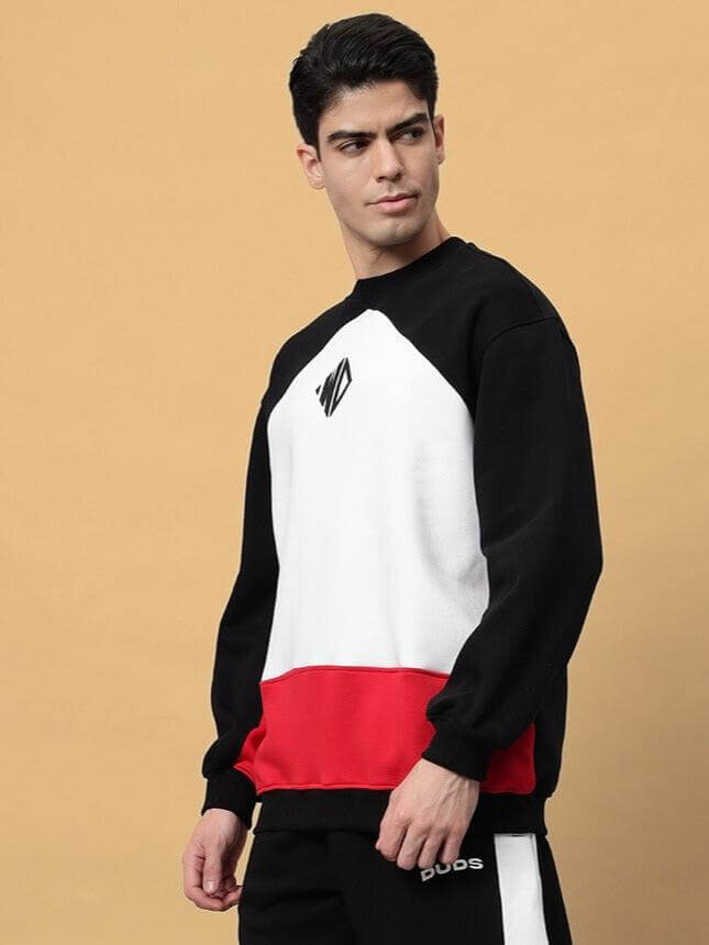 Man wearing a WD Fervid Fleece Colorblock Sweatshirt in black, white, and red color, featuring a logo on the chest.