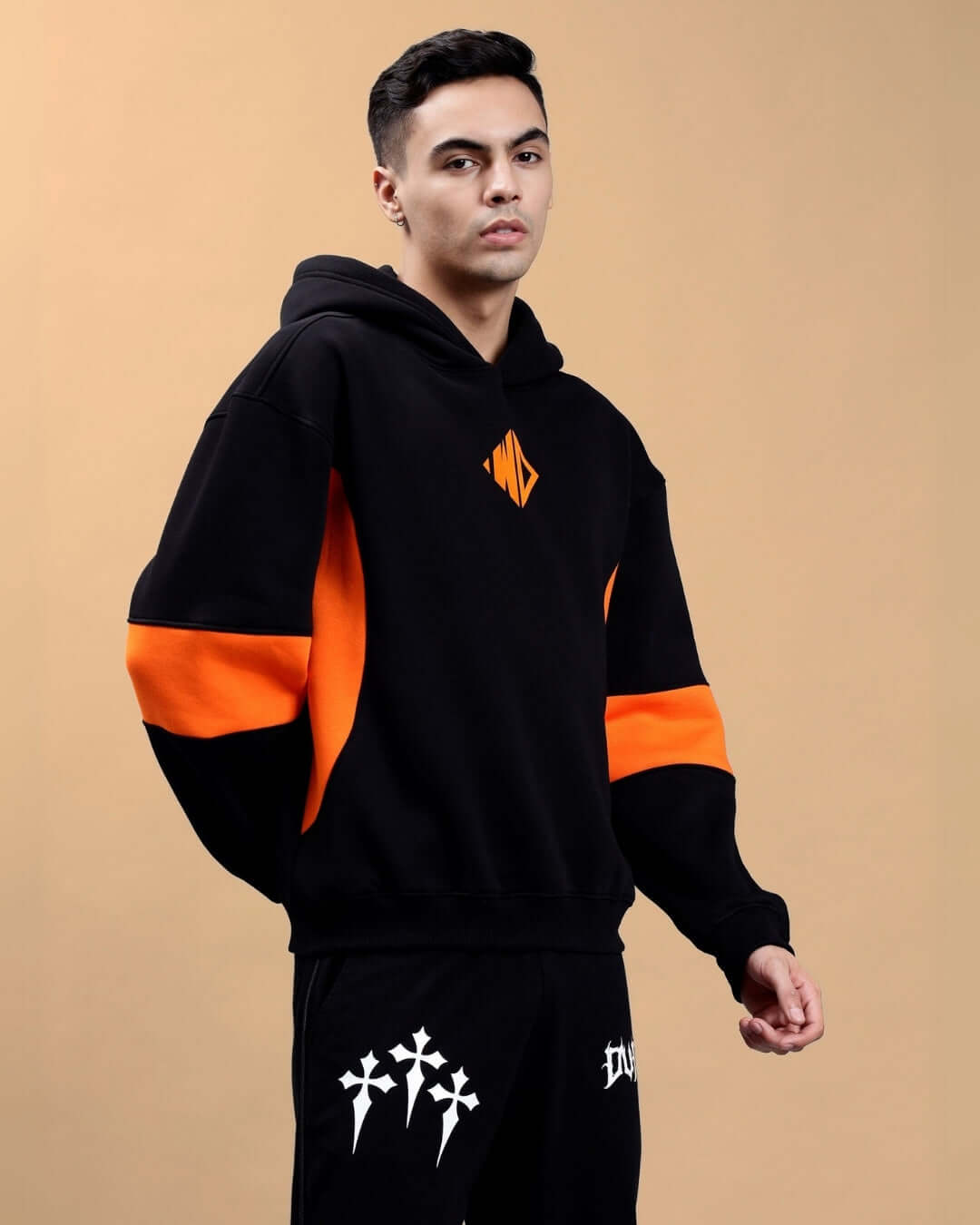 WD Gorpcore black and orange colorblock hoodie worn by male model against neutral background, showcasing casual streetwear style.