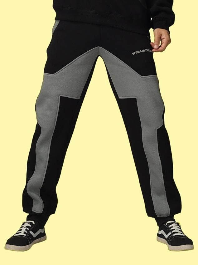 WD GORBCORE Fleece Colorblock Cargo Pant in black and grey, featuring a stylish and modern design, worn with sneakers against a yellow background.