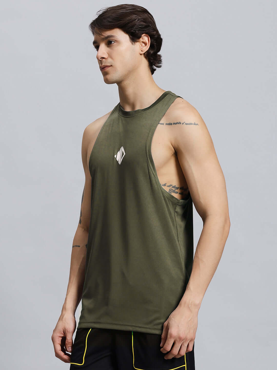 Man wearing WD STRINGER GYM SLEEVELESS T-SHIRT GREEN, showcasing athletic build in a stylish and breathable gym tank, perfect for workouts.