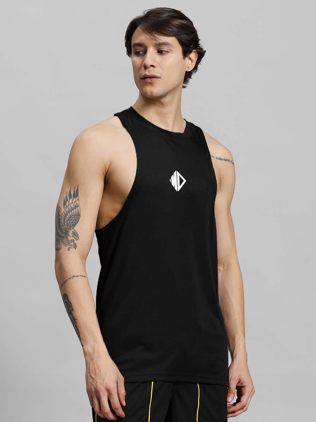 Man wearing WD STRINGER GYM SLEEVELESS T-SHIRT BLACK with logo, showcasing comfortable gym attire.