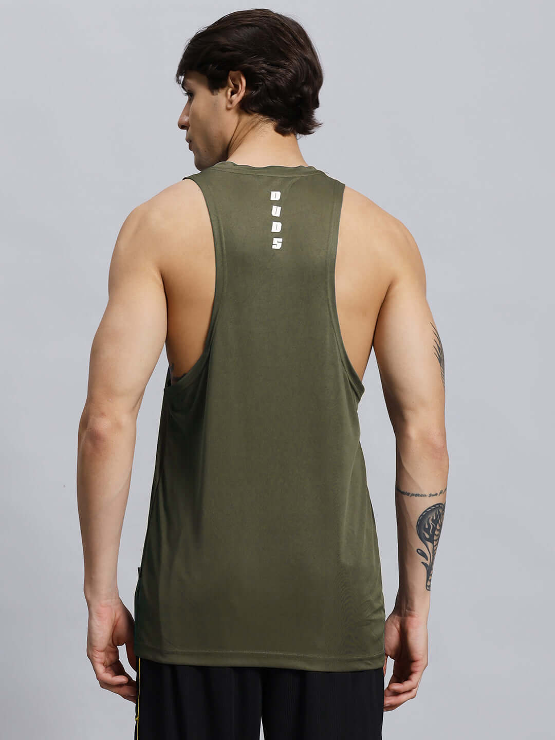 Back view of a man wearing a WD STRINGER GYM SLEEVELESS T-SHIRT GREEN showcasing its design and fit.
