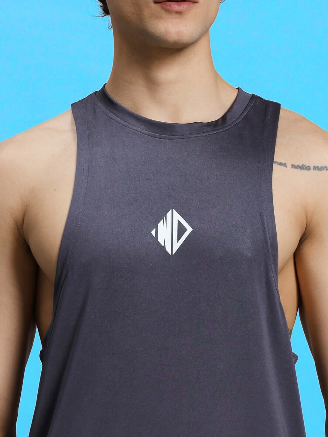 WD STRINGER SLEEVELESS GYM T-SHIRT GREY shown on a model with blue background, highlighting workout apparel style.