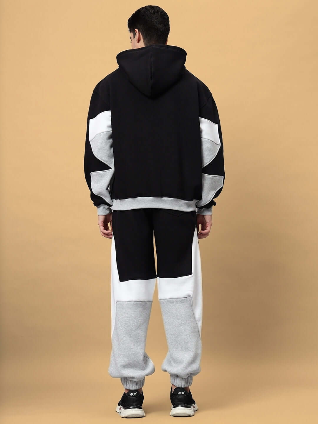 Model wearing WD Sword Fleece Colorblock Cargo Pant and hoodie, showcasing bold streetwear design and cozy fleece fabric from the back.