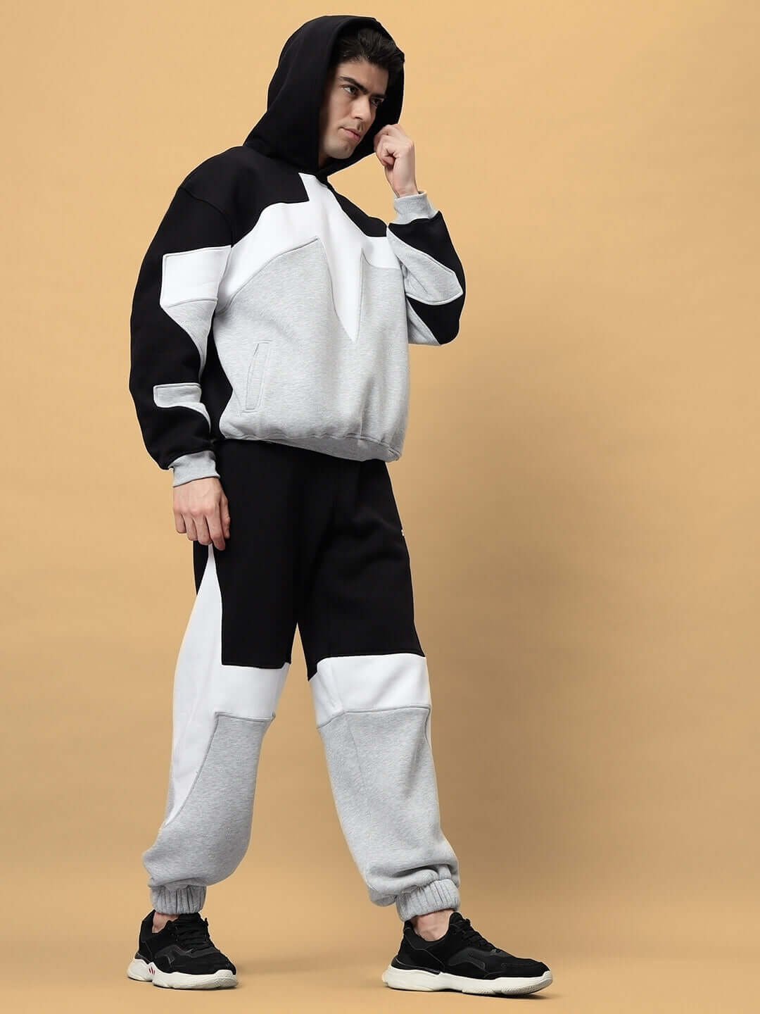 Model wearing WD Sword Fleece Colorblock Cargo Pant with streetwear style, featuring black and white panels, and functional pockets.