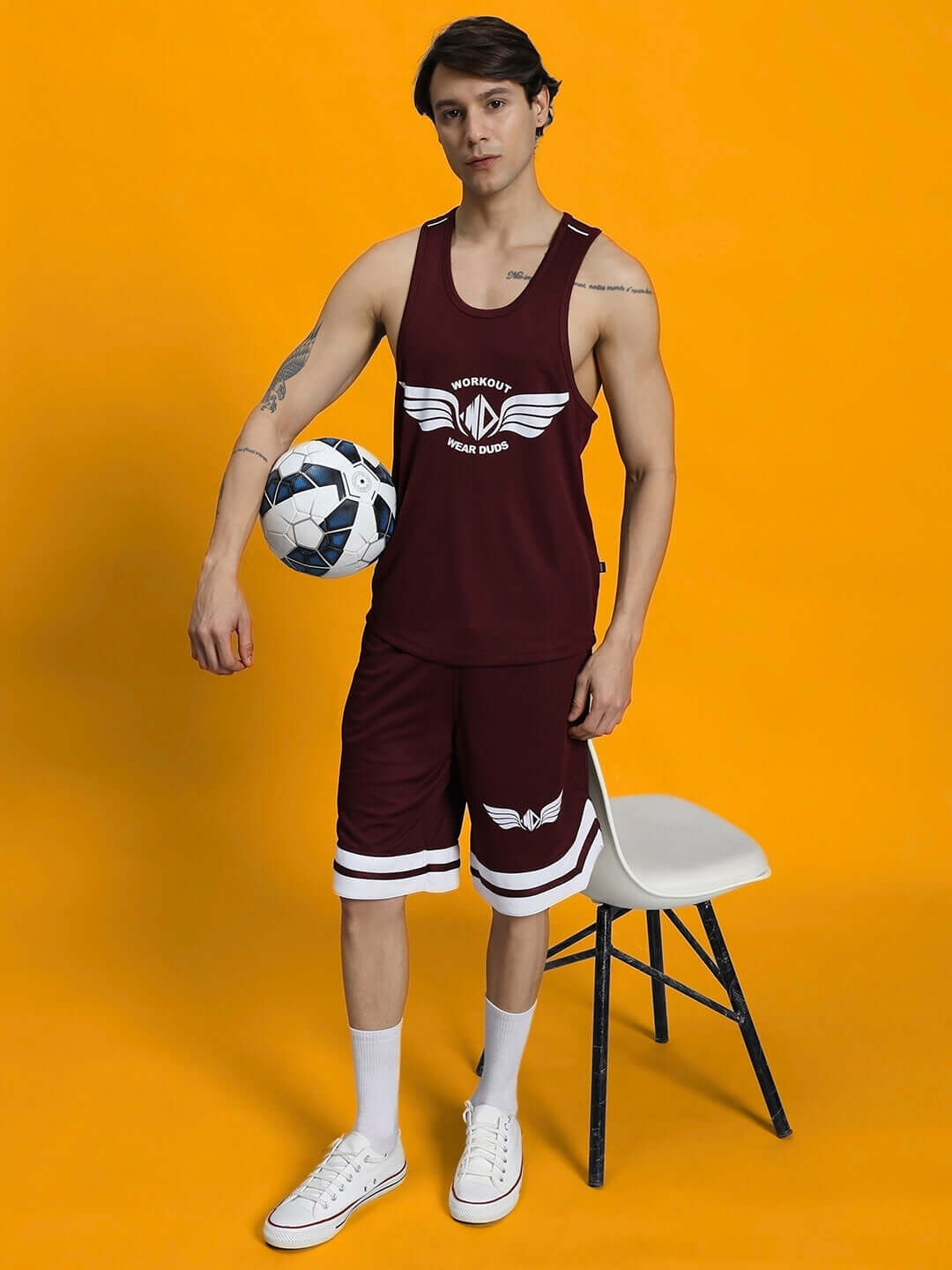 Man wearing WD WINGS GYM CO-ORD SET MAROON holding soccer ball in stylish activewear