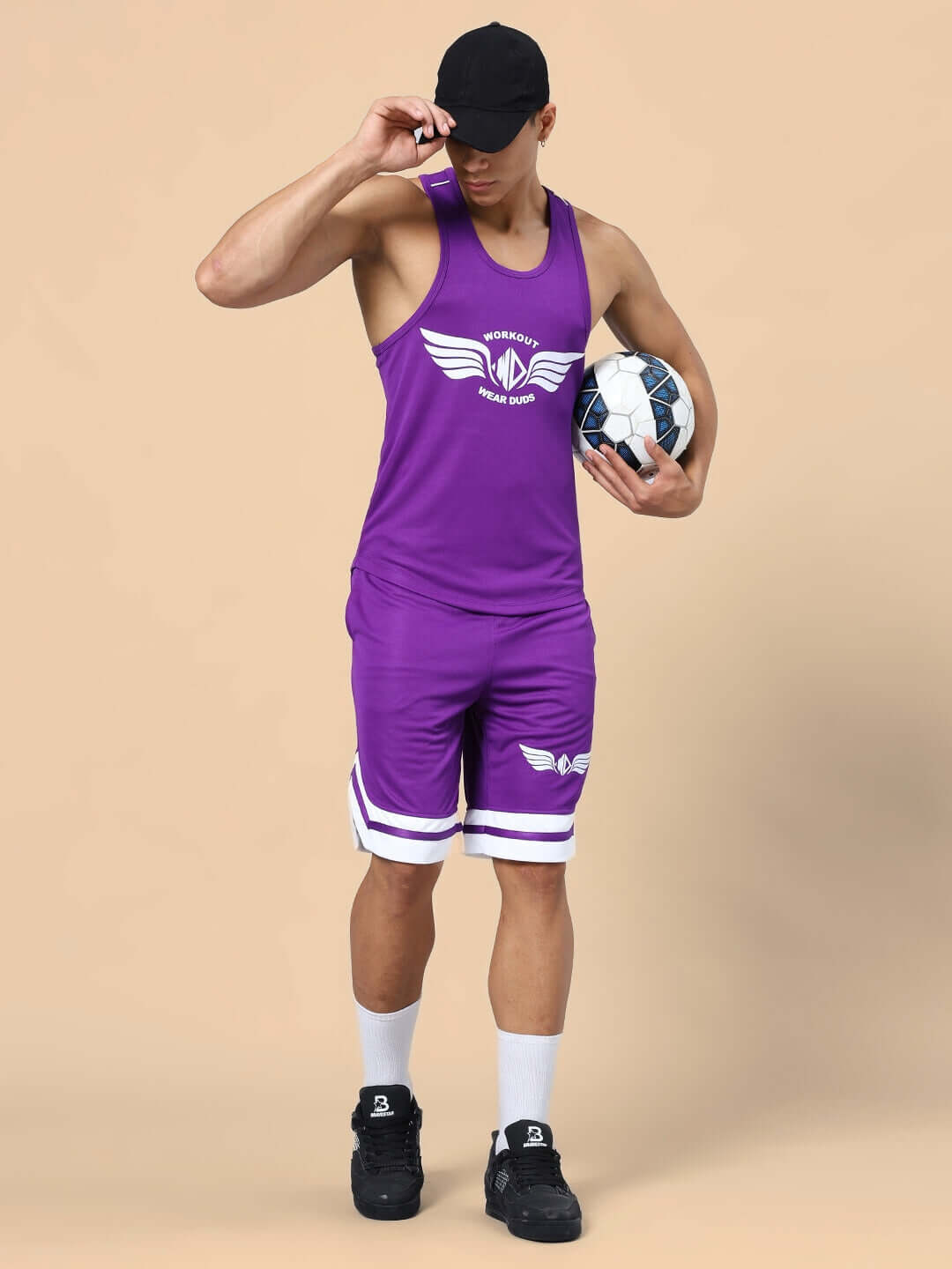 Man wearing WD WINGS GYM CO-ORD SET PURPLE with a soccer ball, featuring a tank top and shorts, demonstrating athletic style and comfort.