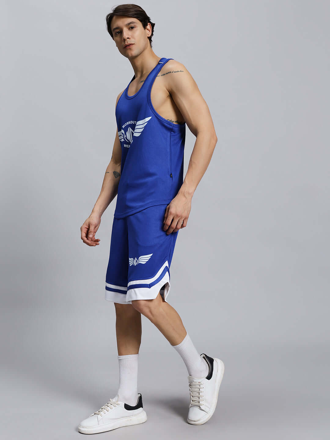 Man wearing WD WINGS GYM CO-ORD SET MEN ROYAL BLUE, featuring a tank top and shorts, stylish and ideal for workouts.