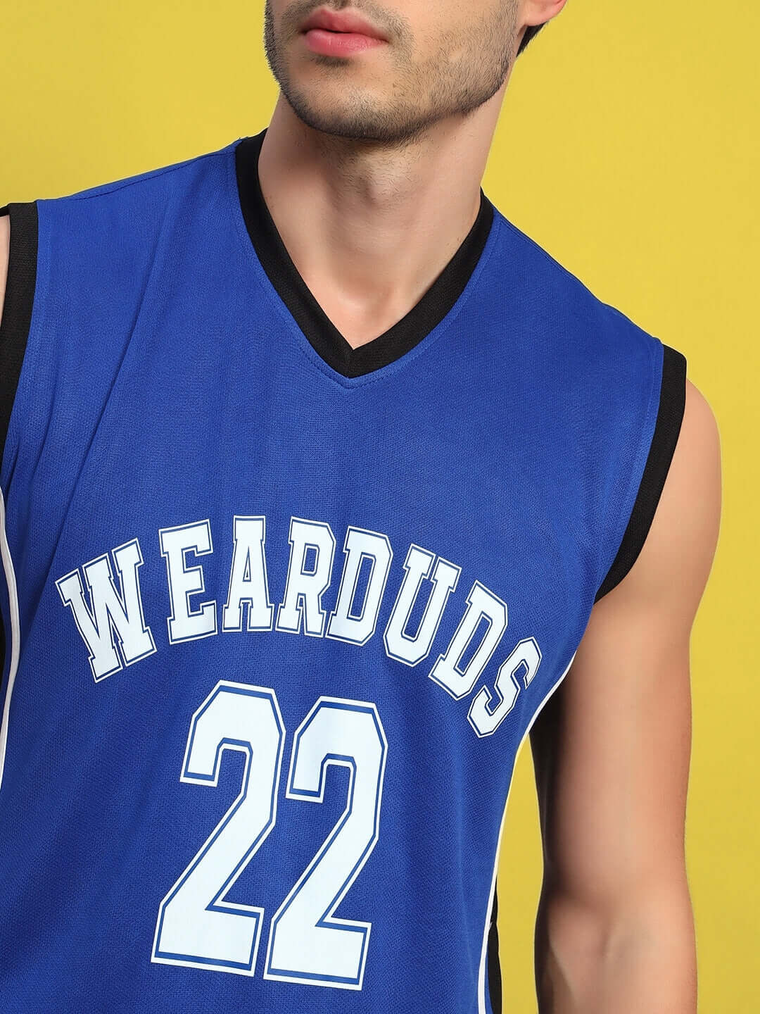 Man wearing a blue basketball jersey with 'WEARDUDS 22' against a yellow background