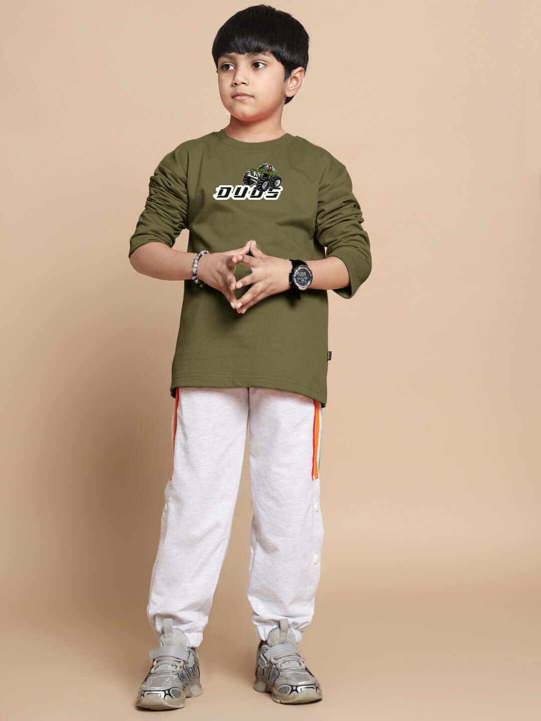 Boy wearing olive green oversized sweatshirt with truck design, suitable for boys and girls. Made of 100% cotton, bio-washed fabric.