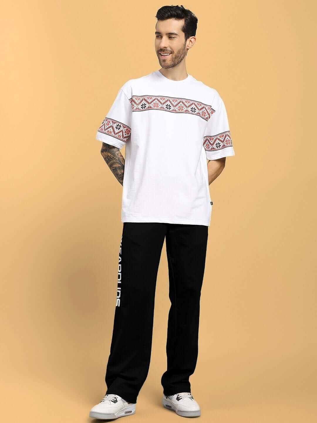 Model wearing ROGER RELAXED-FIT JOGGERS BLACK with a white patterned shirt, showcasing stylish streetwear with comfort and versatility.