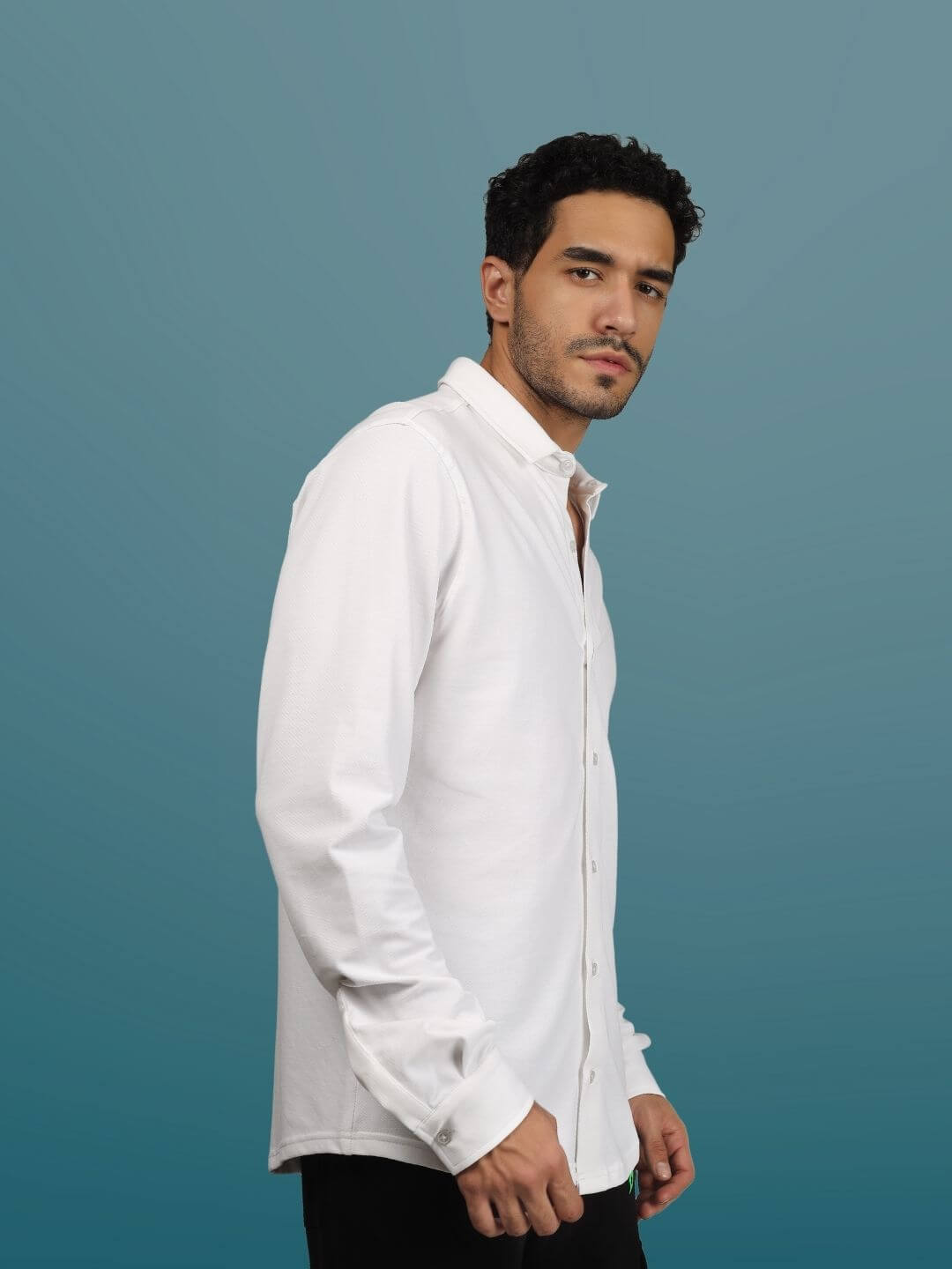 White sporty pique shirt with full sleeves, worn by a model. Features include 4-way stretch, wrinkle-free, and quick dry. Ideal for all-day comfort.