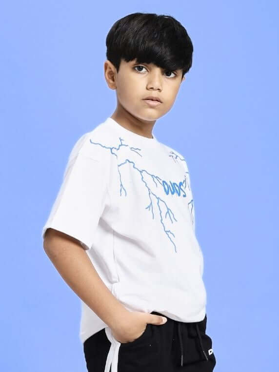 Child wearing MARVEL BLACK PANTHER T-SHIRT FOR BOYS AND GIRLS WHITE with a blue graphic, standing against a blue background.