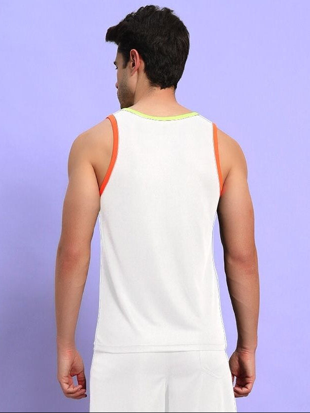 Man wearing a white tank top with orange accents, viewed from the back, standing against a light purple background.