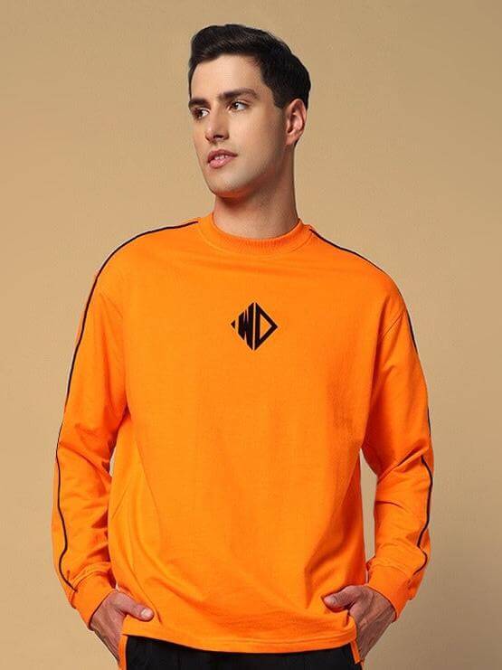 Model wearing orange WHOPPER oversized sweatshirt made from premium cotton, featuring a logo design, showcasing casual style and comfort.