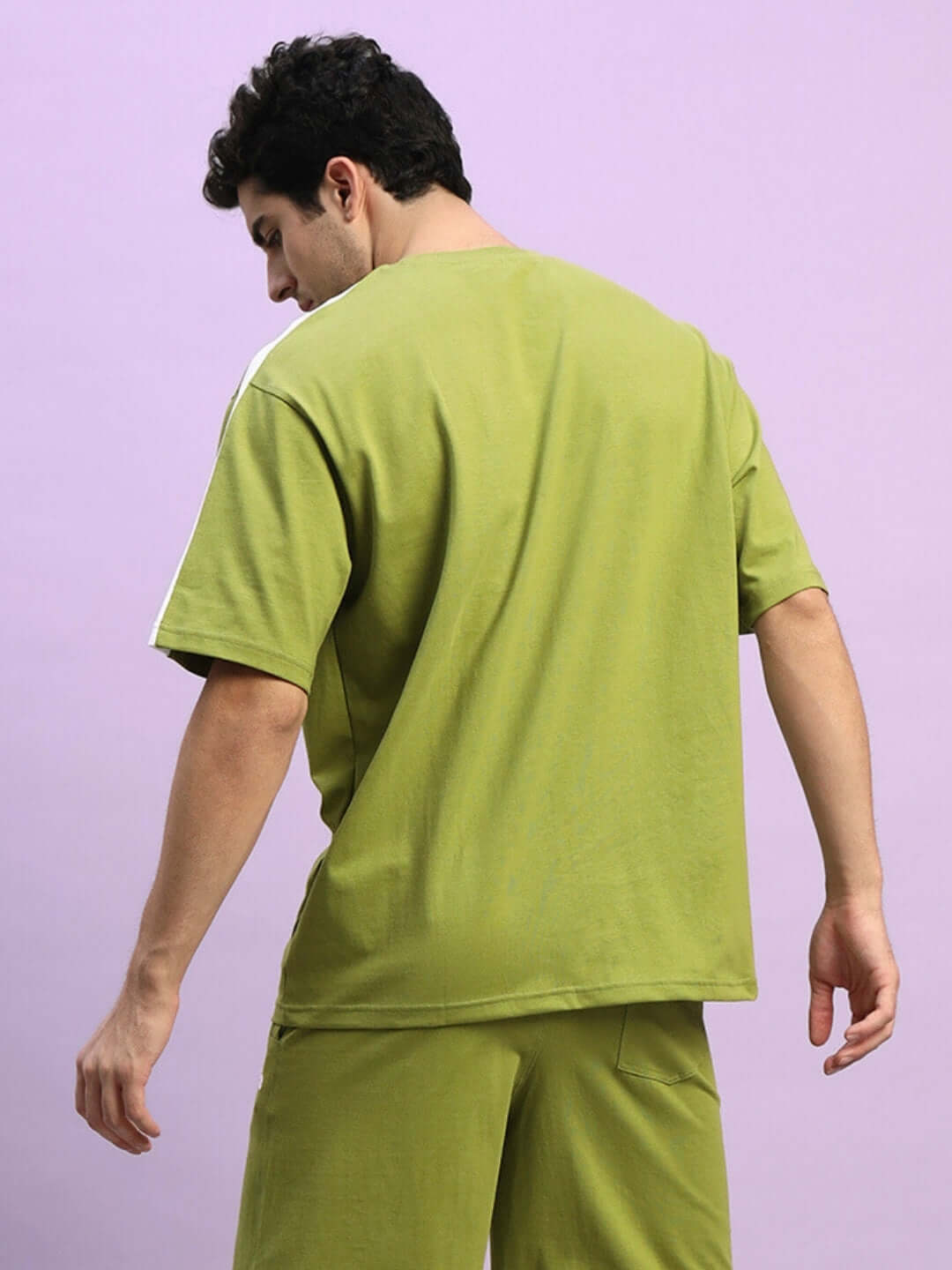 Man wearing WIDELINE OVER-SIZED T-SHIRT OLIVE GREEN made of premium cotton fabric with relaxed fit.