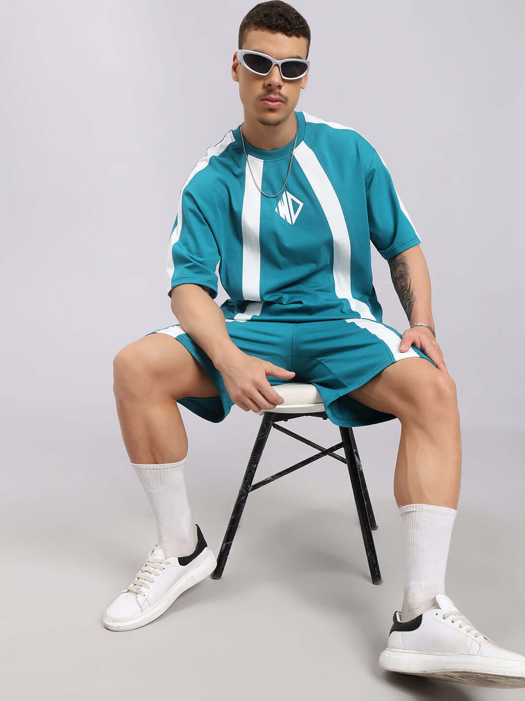 Model wearing Wideline Regular Fit Shorts Teal with matching top and white sneakers, showcasing clean design and breathable fabric.