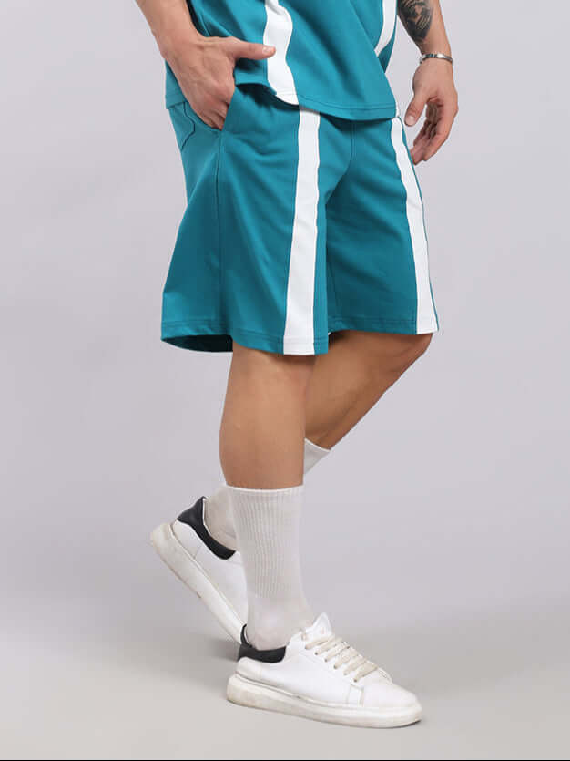 Person wearing Wideline Regular Fit Shorts Teal with white stripe, paired with white socks and sneakers.