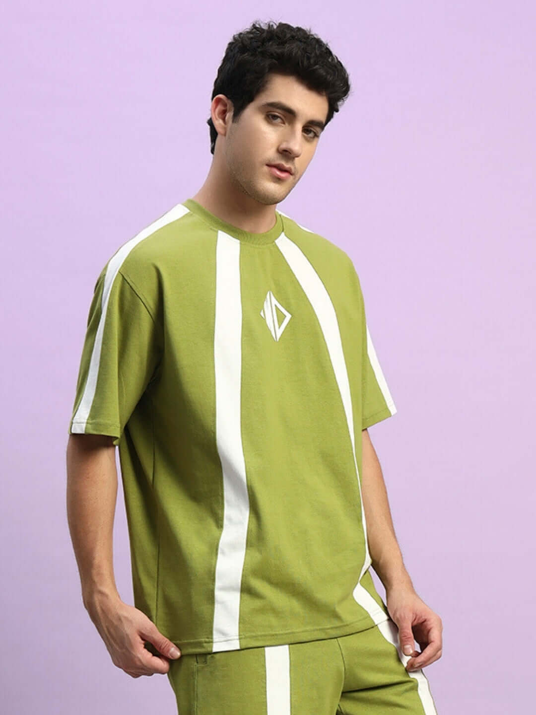 Model wearing WIDELINE OVER-SIZED T-SHIRT OLIVE GREEN made from premium heavy gauge fabric on a purple background