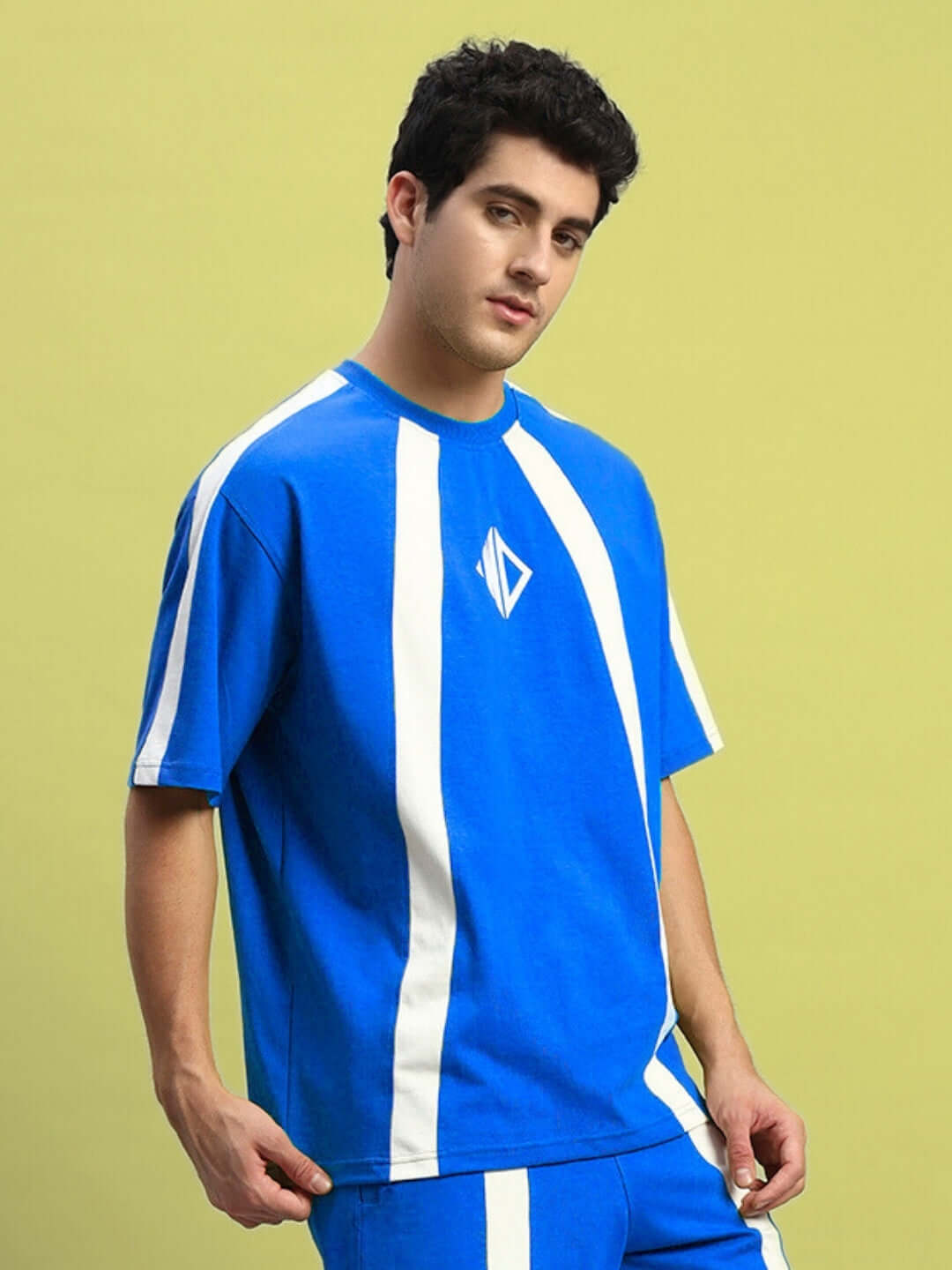 Model wearing Wideline Over-Sized T-Shirt in royal blue with white stripes, showcasing streetwear style and comfort.