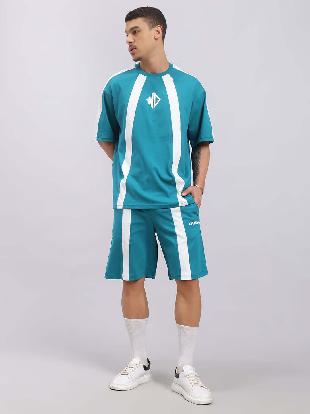 Alt Tag: Man wearing WIDELINE SUMMER CO-ORD SET TEAL with white sneakers, showcasing premium cotton French terry fabric.