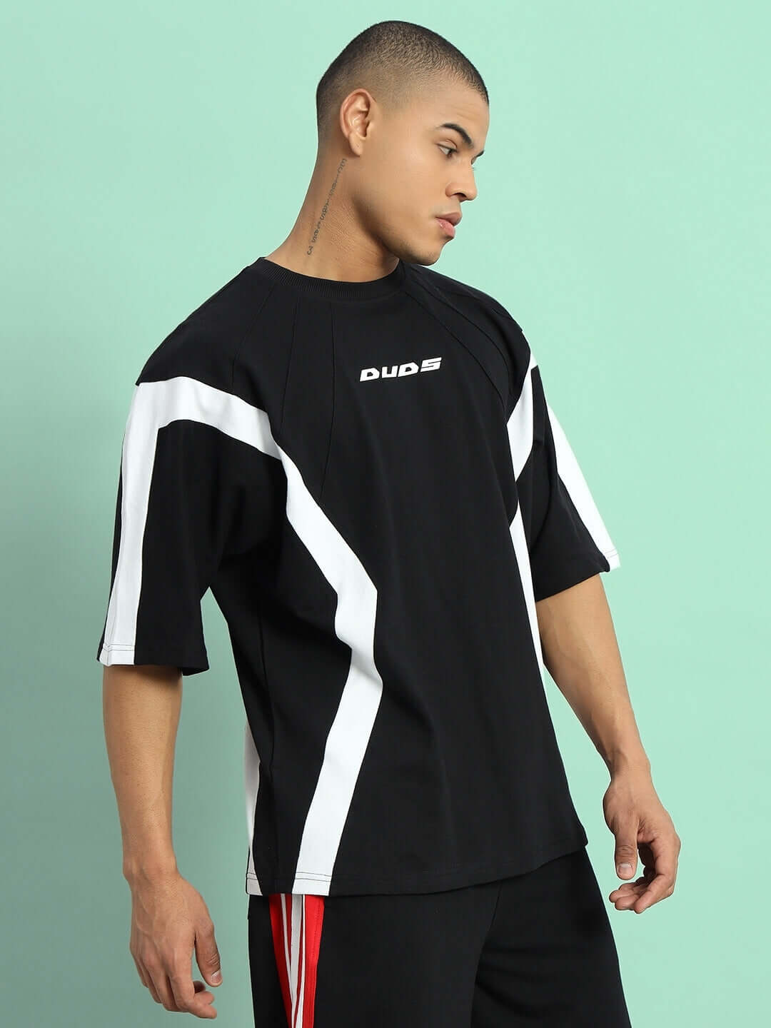 Model wearing a black and white WILD FORCE over-sized T-shirt made from premium cotton fabric, featuring bold stripes, by Color By Colours.