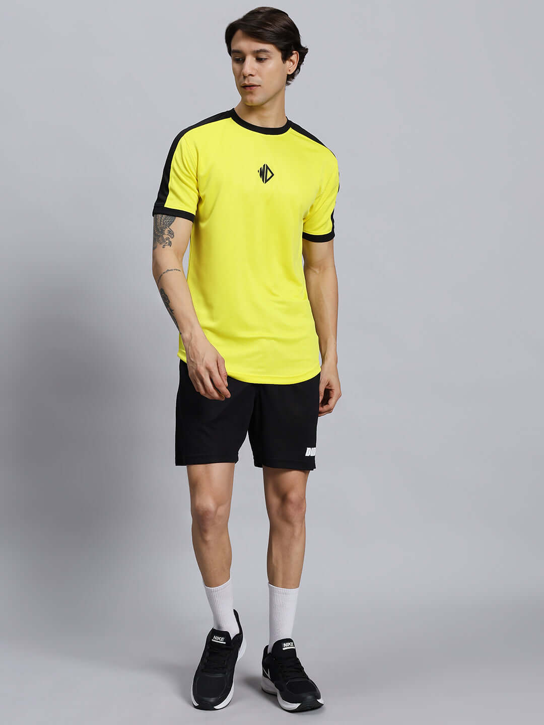 Man wearing WILY TACTICAL REGULAR FIT SHORTS MEN BLACK, paired with a yellow shirt, showcasing outdoor casual wear.