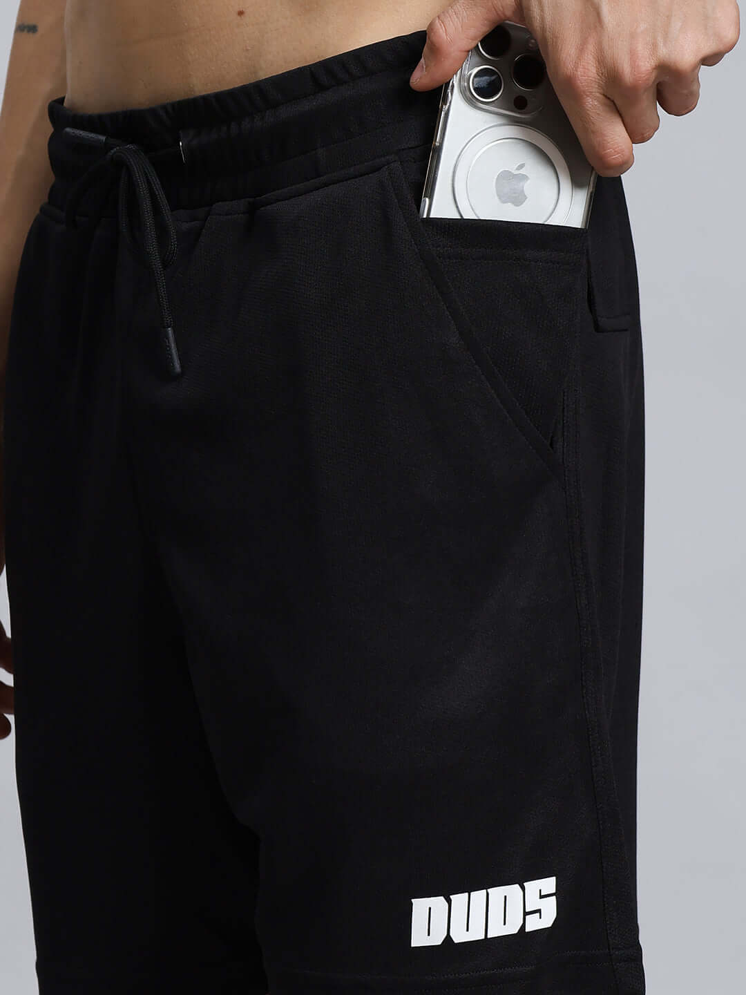 Close-up of WILY TACTICAL REGULAR FIT SHORTS MEN BLACK with phone in pocket, featuring DUDS logo and premium fabric.