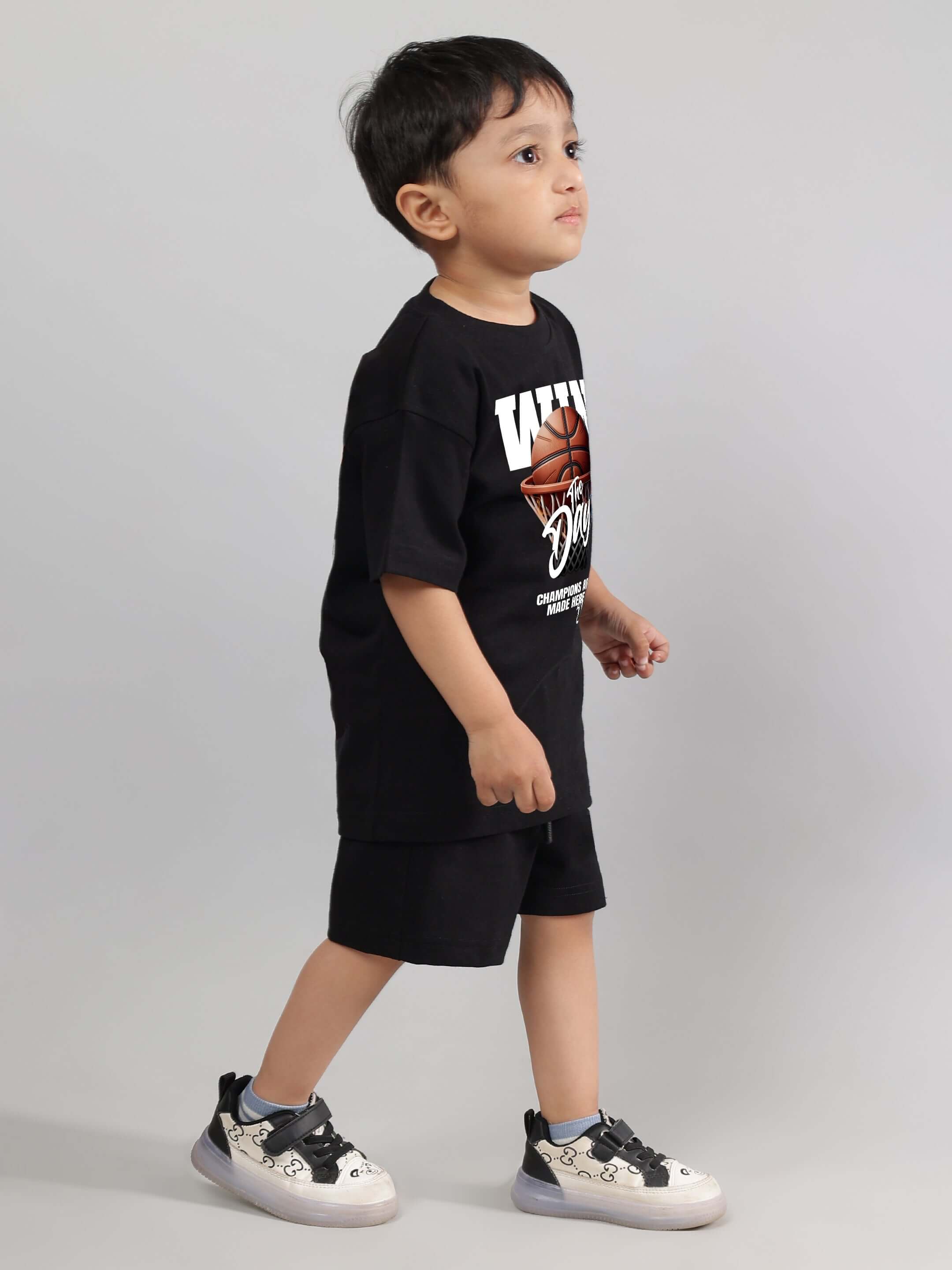 Child wearing WIN DAY CO-ORD FOR BOYS GIRLS BLACK streetwear set, includes graphic t-shirt and shorts, walking confidently.