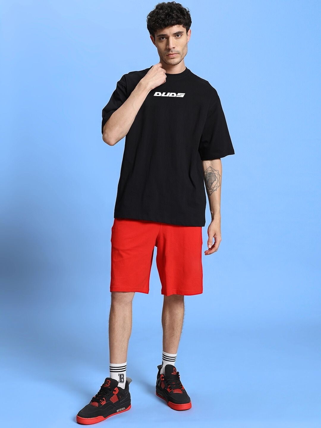 Model wearing WINGED WARRIOR PRINTED OVERSIZED CO-ORD SET BLACK RED, showcasing street-style fashion.